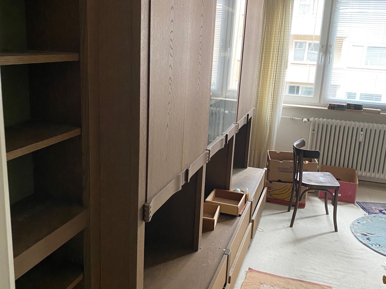 Zimmer mit Schrankwand und Kartons vor der Wohnungsauflösung